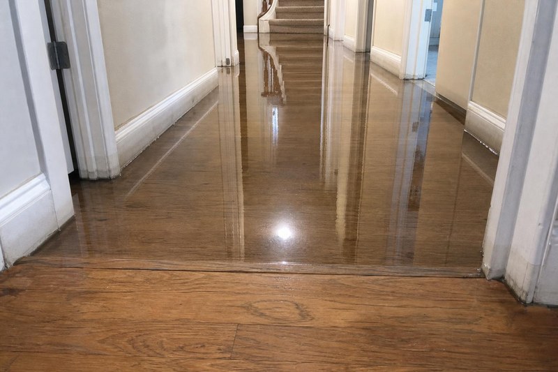 Water standing across the hardwood entry and hallway of a Salt Lake City home after a supply line let go