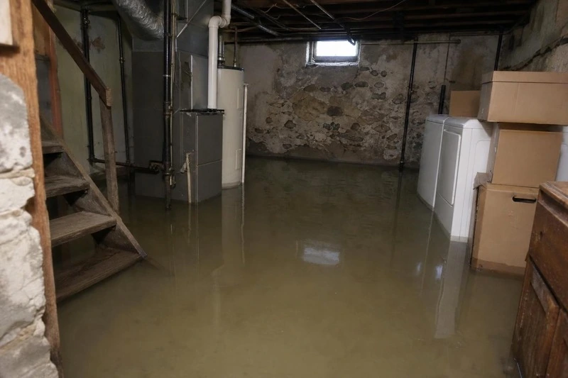 Several inches of snowmelt cover the concrete slab in a Draper basement, and more comes through the window well