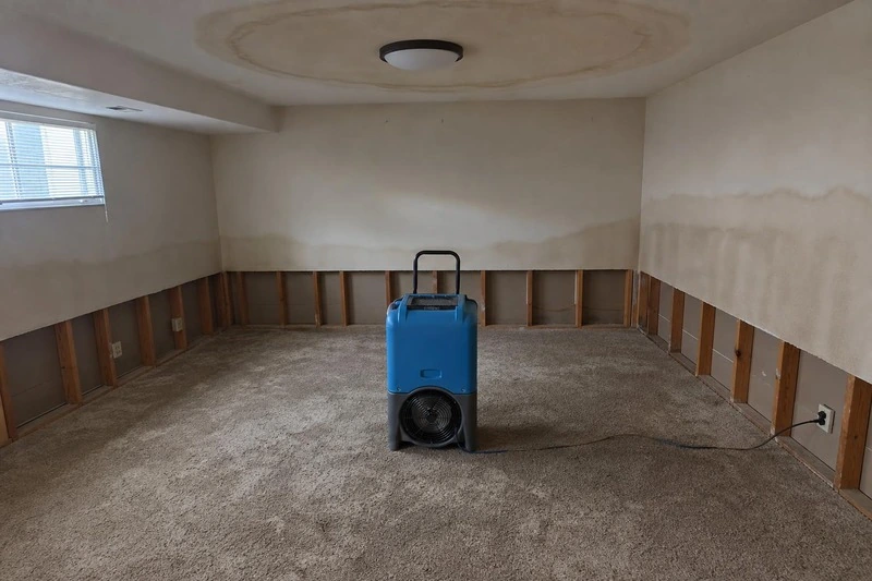 One floor down, a dehumidifier runs on the dried carpet under the stained ceiling ring
